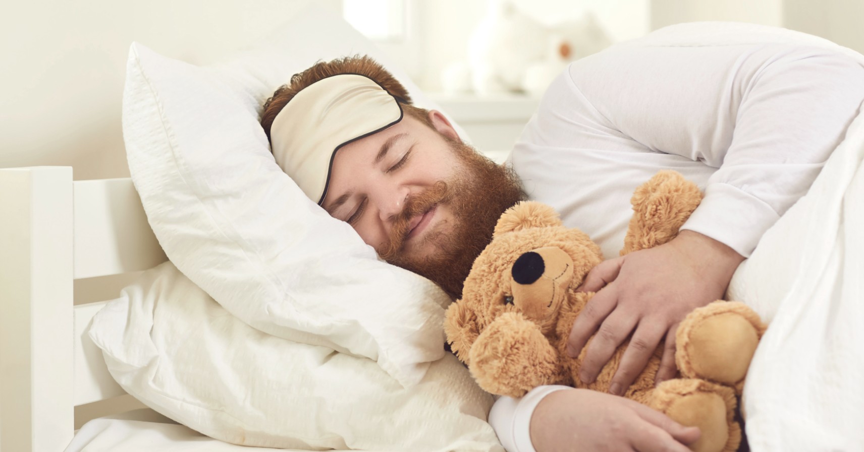 man asleep with teddy bear
